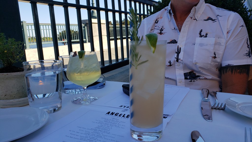 cocktails on a table with riverwalk scene beyond