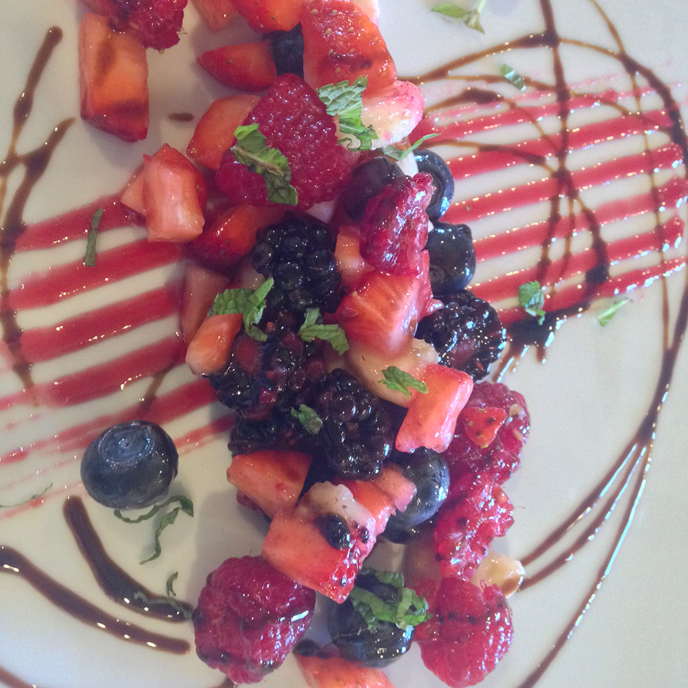 Fresh berries on plate decorated with lines of sauce