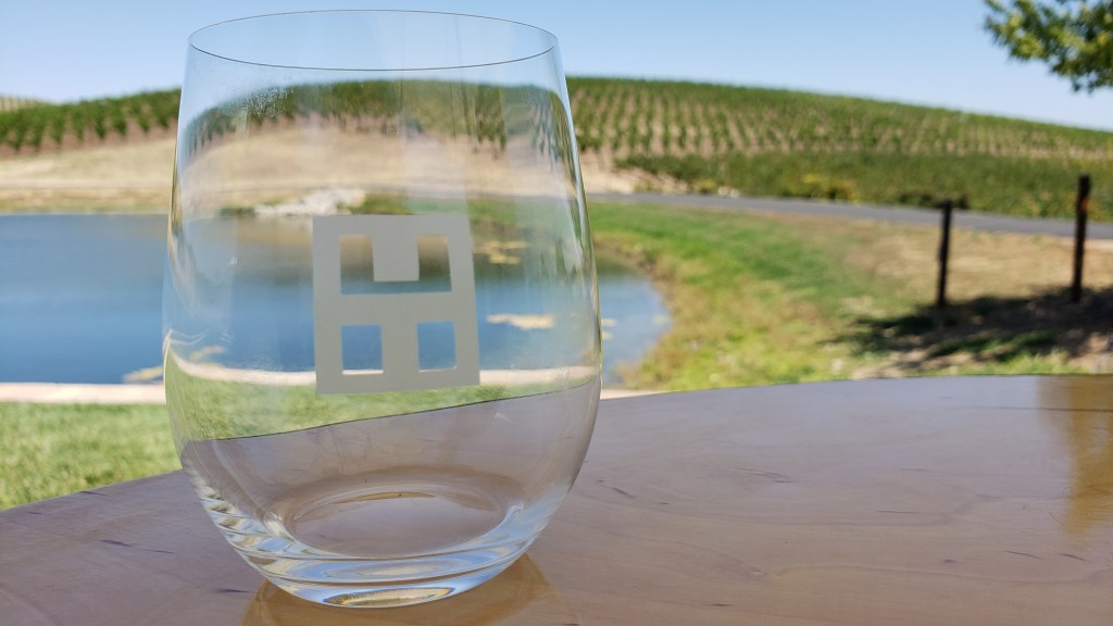 wine glass on table with pond in background