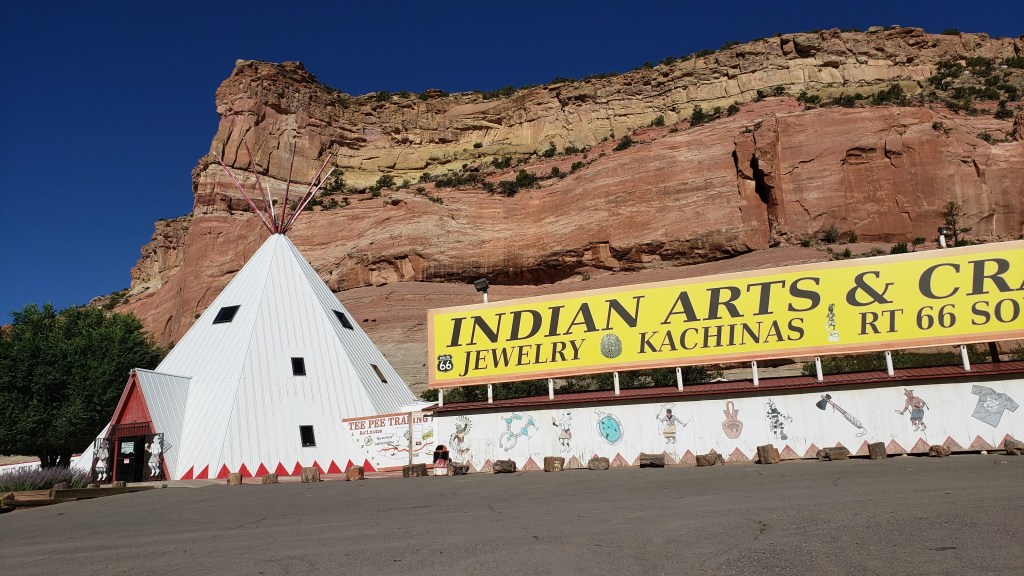 Giant teepee against rock cliff
