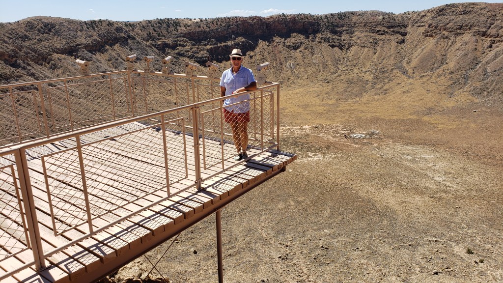 man standing on platform over crater