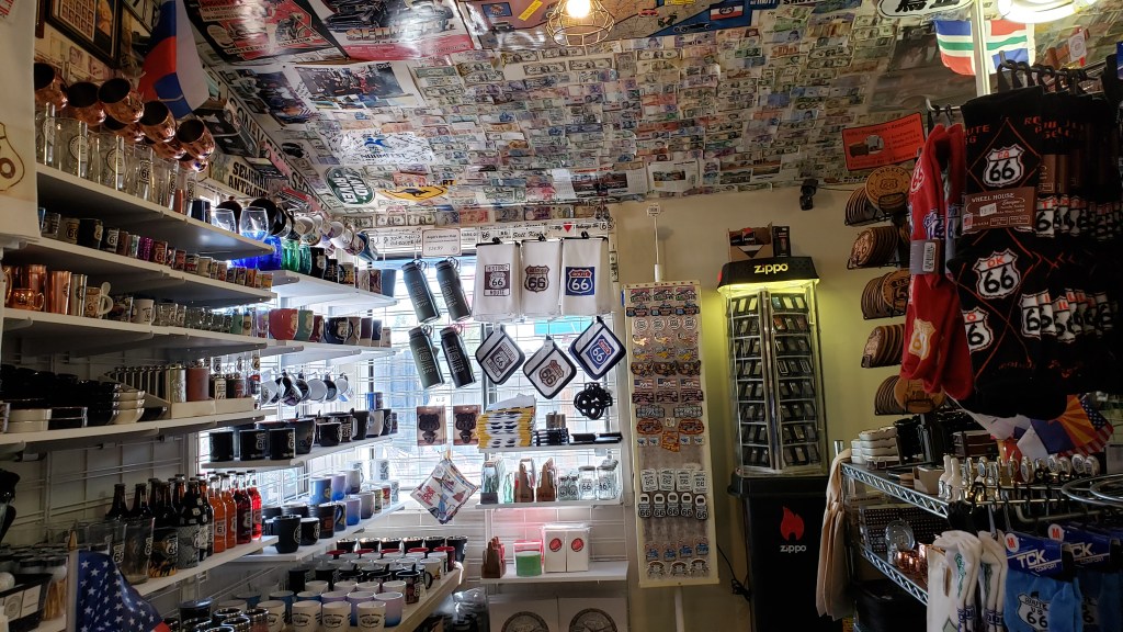 souvenir shop with hundreds of patches and foreign currency bills on ceiling