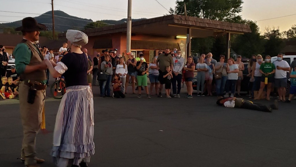 cowboy holding girls hand with fake dead cowboy in background